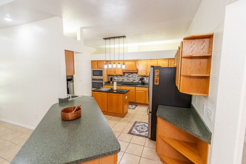 After: Michaels House kitchen with island, wood cabinets and pendant lights, guest-ready