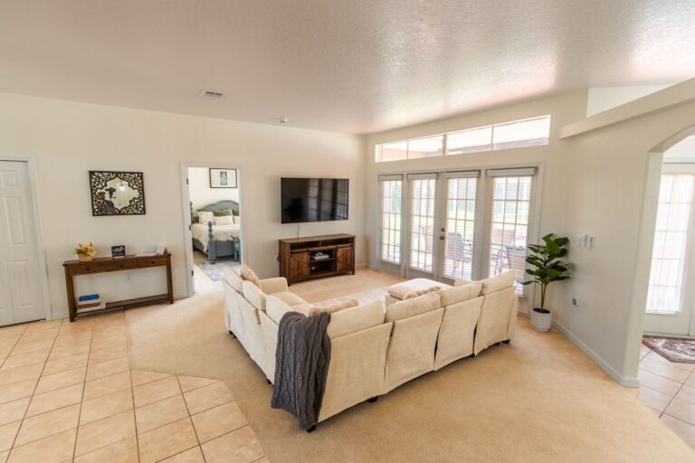 After: Michaels House living room with a cream sectional, console table and TV wall, Airbnb makeover in Hernando County FL