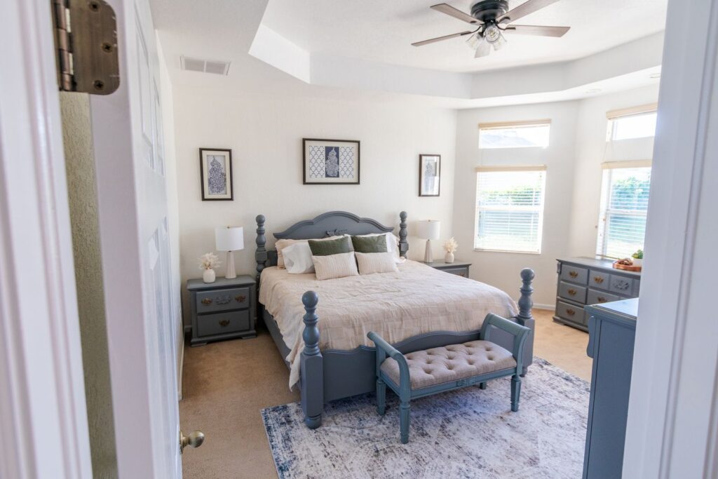 After: Michaels House primary bedroom with a king bed, bay windows and ceiling fan