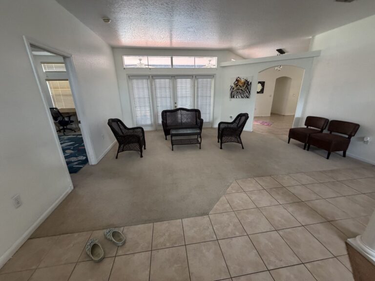 Before: Michaels House family room with wicker furniture and worn carpet