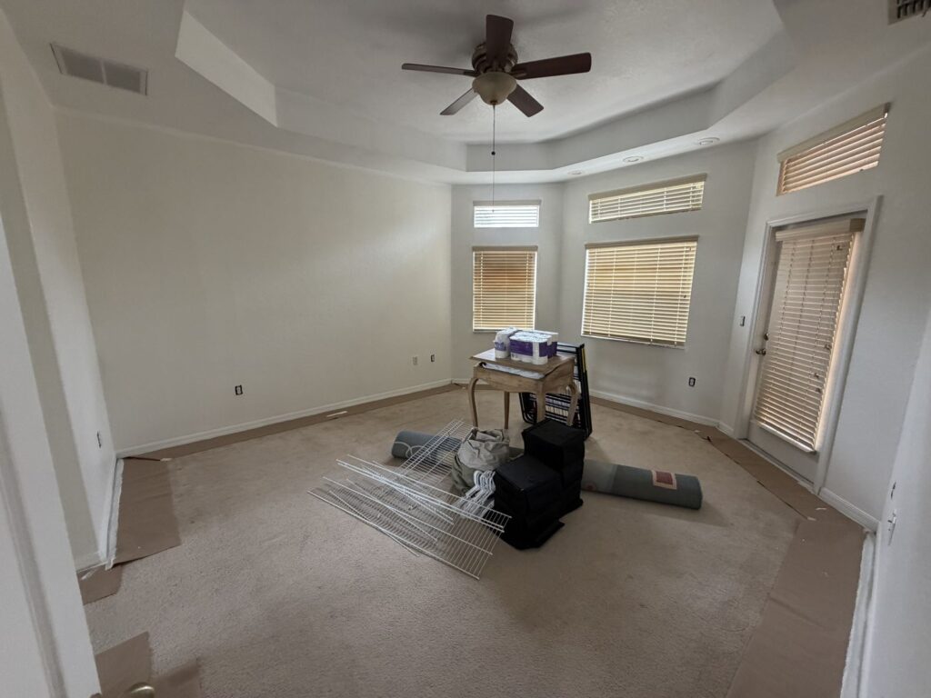 Before: Michaels House primary bedroom, empty with boxes on the carpet